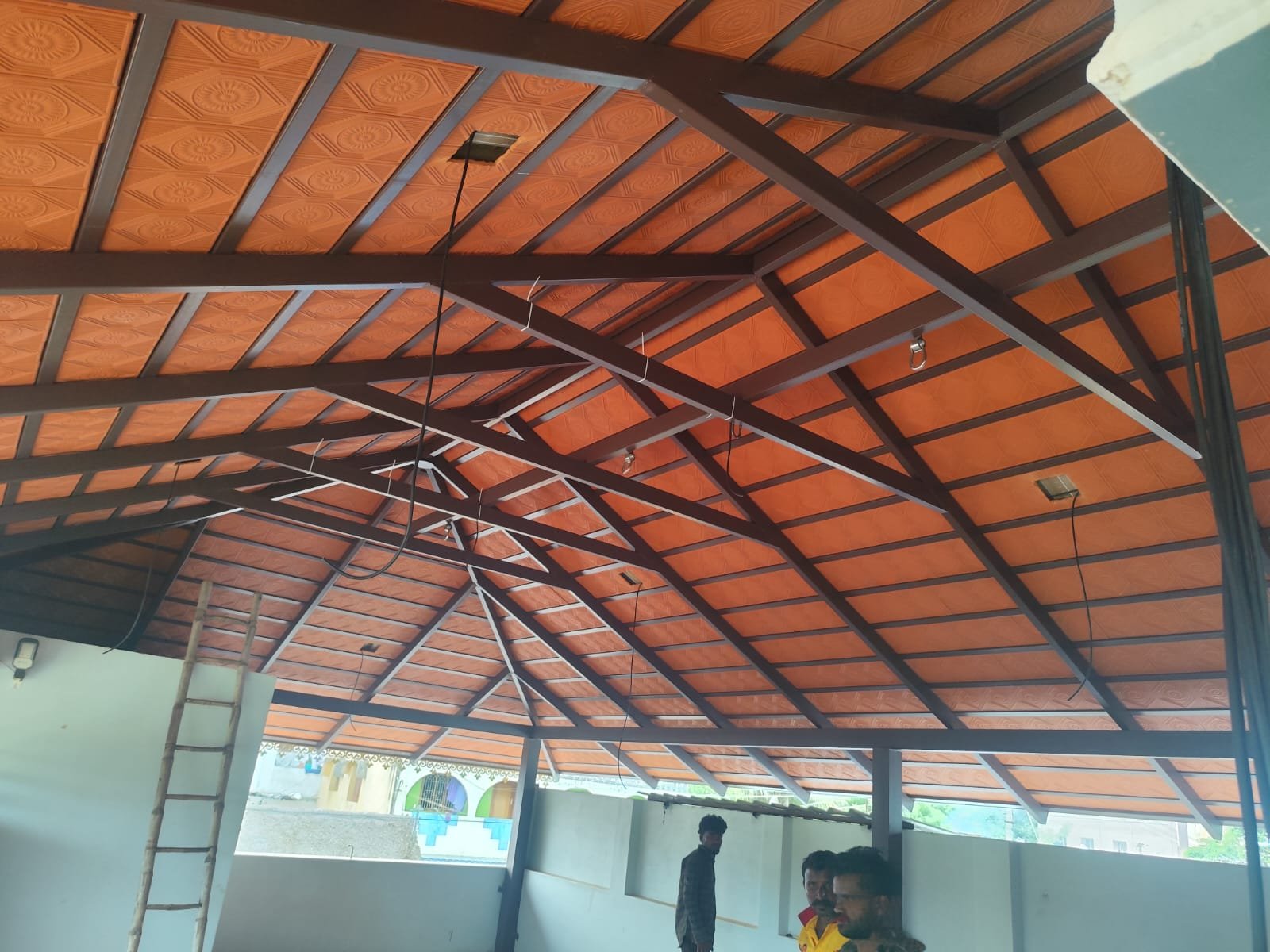 Large hall interior with steel trusses and embossed ceiling panels