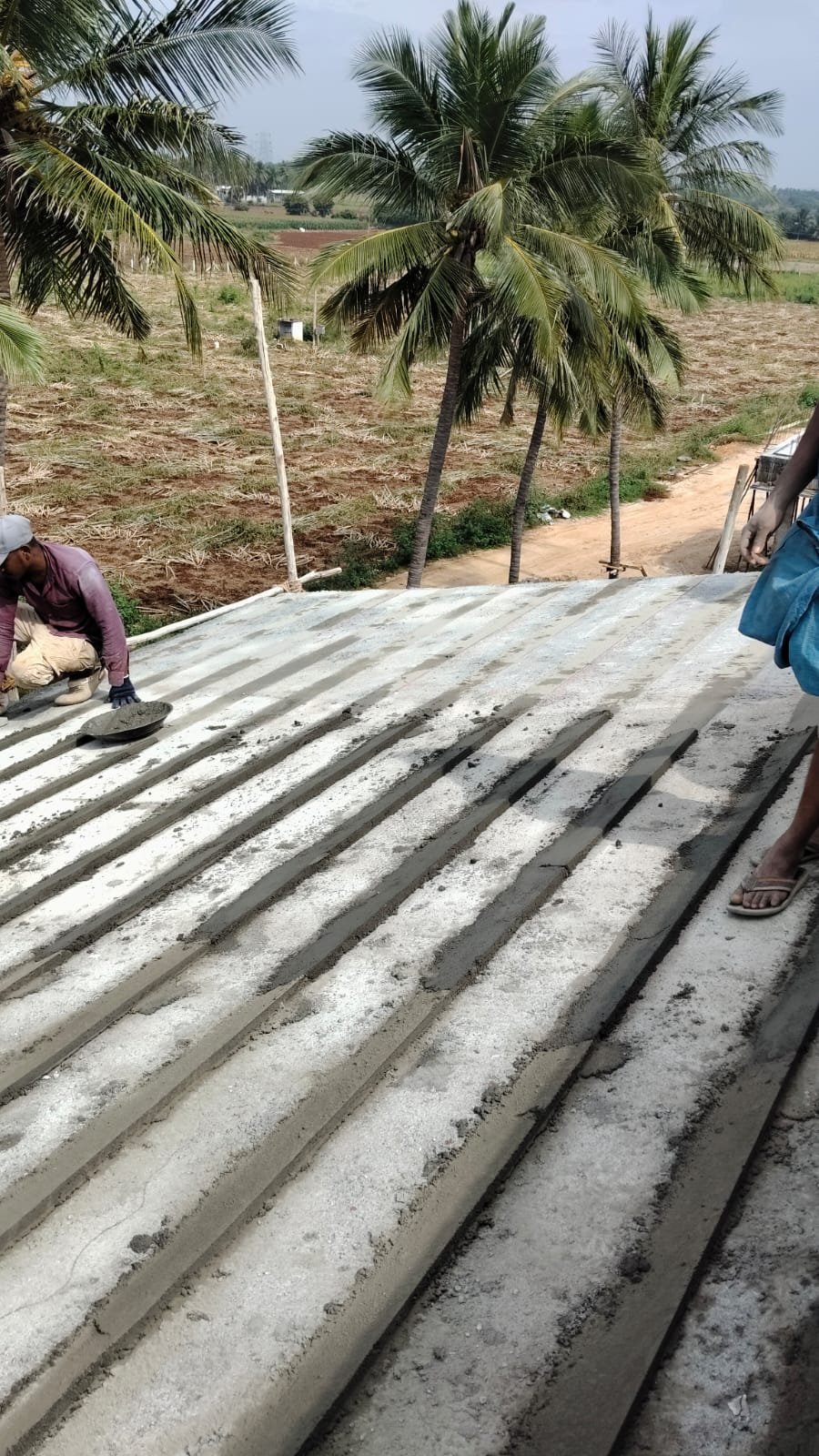 Workers preparing roof base with cement screed strips